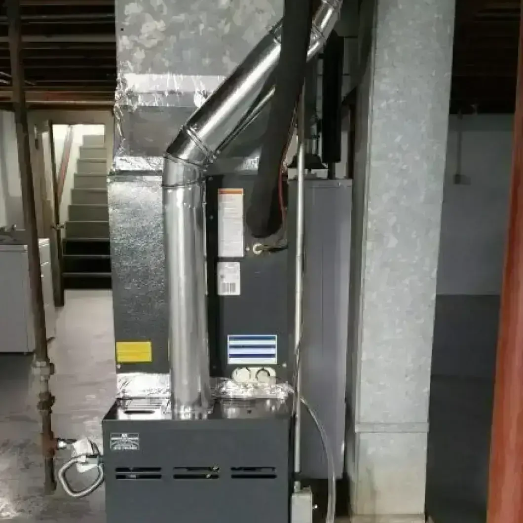 Goodman brand furnace installed in a basement, featuring connected ductwork and ventilation pipes, part of a residential heating system.